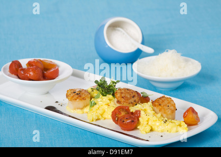 Saffron risotto aux pétoncles grillés et sauce aux tomates cerises Banque D'Images