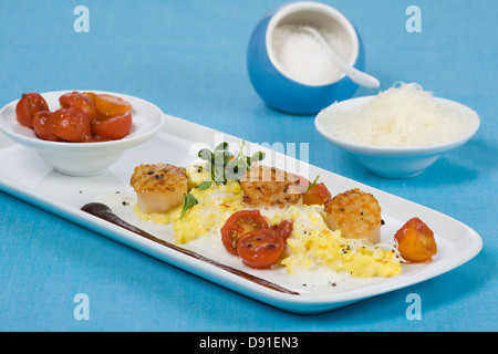 Saffron risotto aux pétoncles grillés et sauce aux tomates cerises Banque D'Images