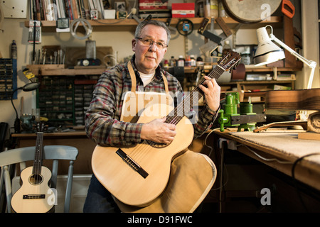 Tuning fabricant de guitares guitare acoustique et d'essai en atelier, portrait Banque D'Images