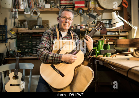 Tuning fabricant de guitares guitare acoustique et d'essai en atelier, portrait Banque D'Images