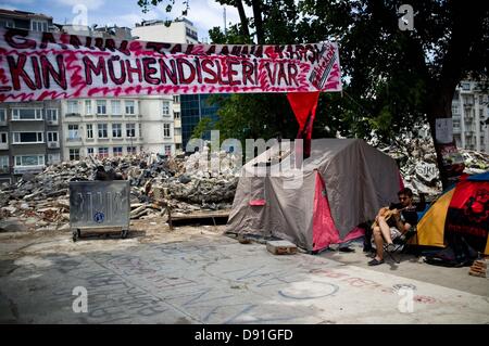 Istanbul, Turquie. 8 juin, 2013. Un homme qui joue de la guitare sous une seule bannière. Pendant plusieurs jours la vie est passé dans le camp de Gazi Park à Istanbul depuis le début des manifestations contre les excès de l'action de la police contre les protestant contre la coupe à blanc des arbres. Crédit : Jordi Boixareu/Alamy Live News Banque D'Images