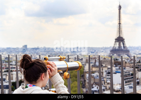 À la fille à la Tour Eiffel par l'observation télescope sur le toit de l'Arc de Triump Banque D'Images