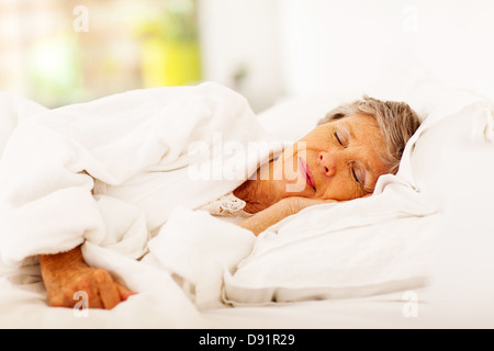 Senior woman sleeping on bed Banque D'Images