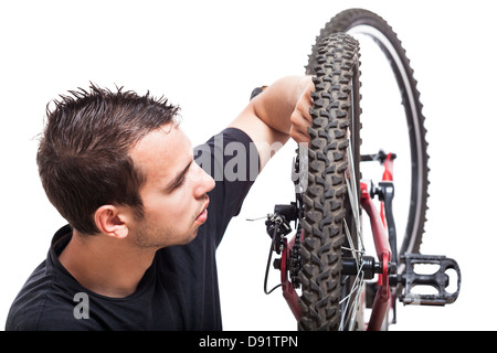 Jeune homme contrôle de sa bicyclette, isolé sur fond blanc Banque D'Images