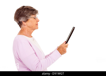 Femme âgée lecture livre sur tablet computer isolated on white Banque D'Images