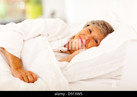 Happy senior woman sleeping on bed Banque D'Images