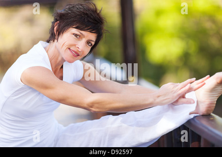 Belle femme d'âge moyen de la jambe d'étirement Banque D'Images