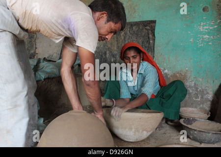 Une femme et son mari faire en argile pichets à l'intérieur de leur maison à la colonie de potiers, Delhi, Inde. Banque D'Images