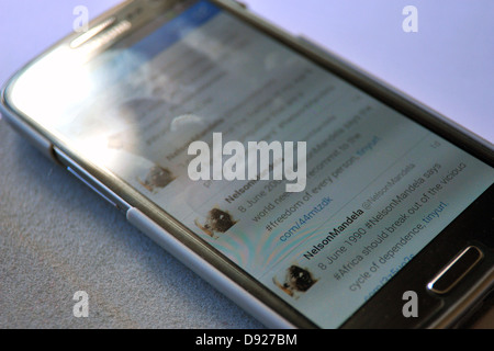 Images de twitter sur un écran de téléphone intelligent avec des messages sur la maladie de l'ancien Président sud-africain Nelson Mandela. Banque D'Images
