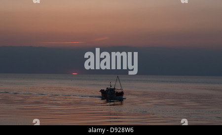 Trawler sur la mer au coucher du soleil. Banque D'Images