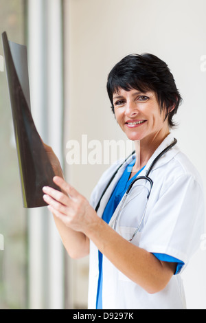 Belle femme médecin d'âge moyen avec x-ray in office Banque D'Images