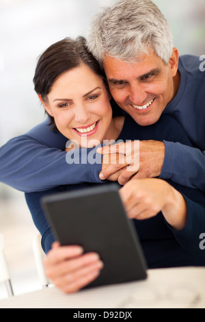 Belle mature couple using tablet computer at home Banque D'Images