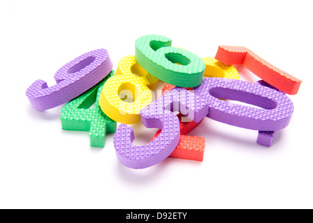 Une pile de numéros colorés en mousse pour enfants sur fond blanc Banque D'Images