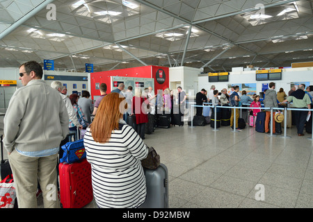 File d'attente au check-in 24 dans terminal de départ, l'aéroport de Stansted, Witham, Essex, Angleterre, Royaume-Uni Banque D'Images