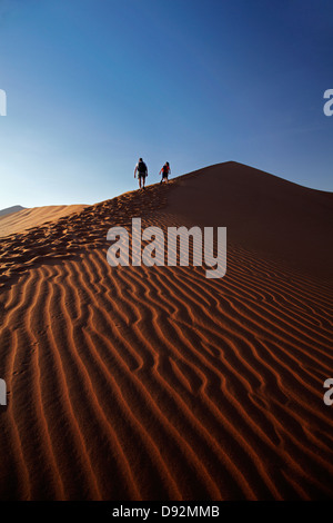 Escalade de la famille à côté des dunes de sable, près de Deadvlei Sossusvlei, Namib-Naukluft National Park, Namibie, Afrique Banque D'Images