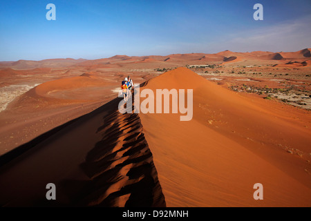 Escalade de la famille à côté des dunes de sable, près de Deadvlei Sossusvlei, Namib-Naukluft National Park, Namibie, Afrique Banque D'Images