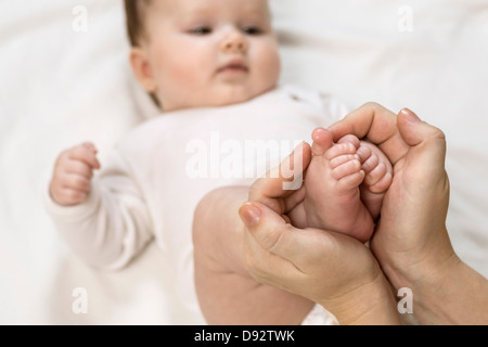 Mère tenant pieds de l'enfant Banque D'Images