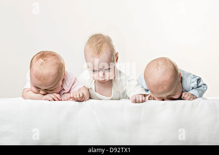 Trois bébés en tirant une ligne funny faces Banque D'Images