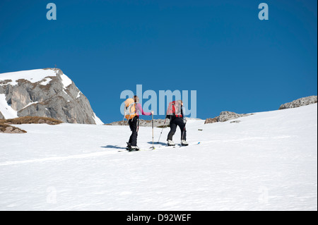 Deux skieurs se déplacer vers le haut d'une colline de neige sur les Dolomites, le Tyrol du Sud, Italie, Banque D'Images