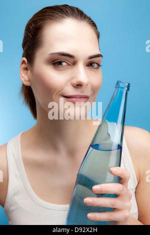 Une jeune femme une bouteille en verre d'eau Banque D'Images