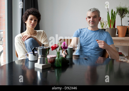 Un mixte de la hanche de l'âge dans leur table à manger moderne Banque D'Images