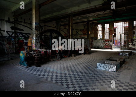 Vue intérieure d'un bâtiment industriel abandonné avec des graffitis sur les murs Banque D'Images