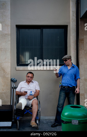 Deux fans de football regardez les téléphones cellulaires pendant la coupe du monde FIFA tirage final carnival sur la rue Longue à Cape Town Afrique du Sud l'un est Banque D'Images