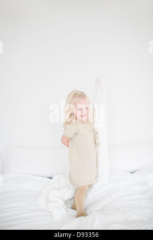 Little Girl standing on bed Banque D'Images