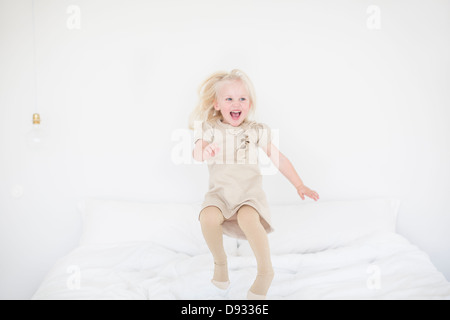 Little girl jumping on bed Banque D'Images