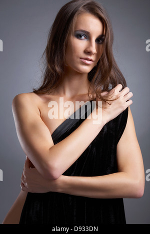 Séduisant jeune modèle couvre sa poitrine avec tissu noir Banque D'Images