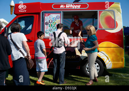 Les clients en attente pour le mur traditionnel Mr Whippy la crème glacée, à partir d'un véhicule en stationnement, à l'extérieur sur une chaude journée d'été. Angleterre, Royaume-Uni. Banque D'Images