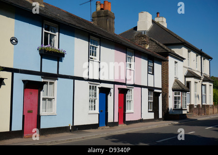 Woodfield couleur cottages - une rangée de maisons mitoyennes contre un ciel bleu clair, en Ashtead, Surrey, Angleterre, Royaume-Uni. Banque D'Images