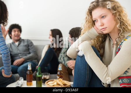 Femme assise en dehors de leurs amis Banque D'Images