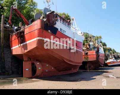 Les chalutiers de pêche commerciale s'appuyant contre le mur du port à marée basse, Ilfracombe, Devon, UK 2013 Banque D'Images