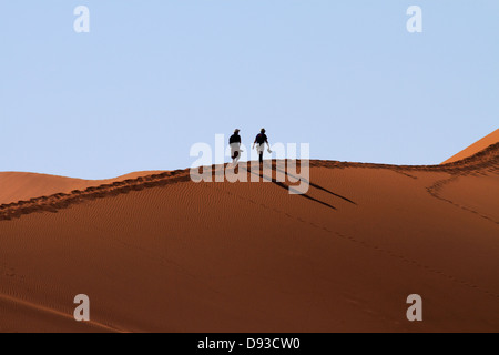 Les touristes à côté des dunes de sable d'escalade Deadvlei, près de Sossusvlei, Namib-Naukluft National Park, Namibie, Afrique Banque D'Images