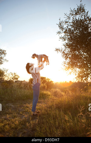 Korean woman Playing with dog in meadow Banque D'Images