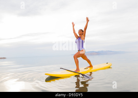 Filipino woman practicing yoga on paddle board Banque D'Images