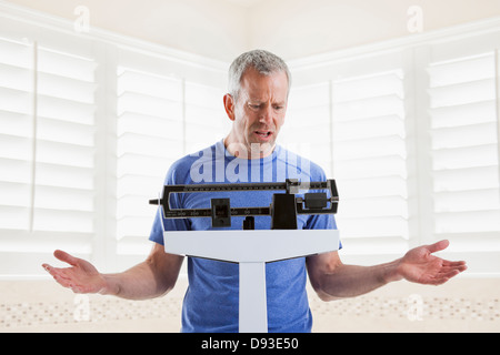 Caucasian man pesant lui-même Banque D'Images