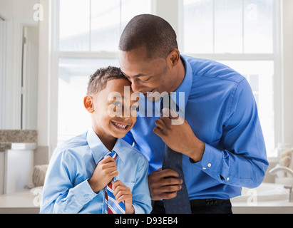 Père et fils se redressant leurs liens Banque D'Images