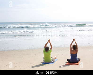 Caucasian couple sitting on beach Banque D'Images