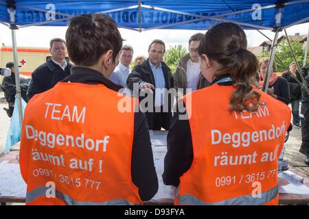 Le ministre allemand de l'intérieur Hans-Peter Friedrich (CSU, C) parle de bénévoles dans le district Fischerdorf à Deggendorf, Allemagne, 10 juin 2013. Friedrich a visité les opérations de nettoyage dans la région d'inondation. Photo : Armin Weigel Banque D'Images