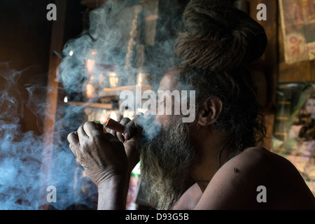 Un hindou Shaivite Sadhu (ascète) allume une chillum (tuyau) dans le district de l'Himalaya de Chamba dans l'Himachal Pradesh, Inde Banque D'Images