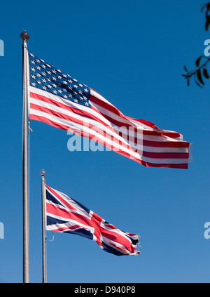 Drapeaux britanniques et américains dans la brise contre un ciel bleu profond Banque D'Images