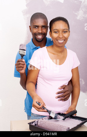 Happy African American couple painting new house Banque D'Images
