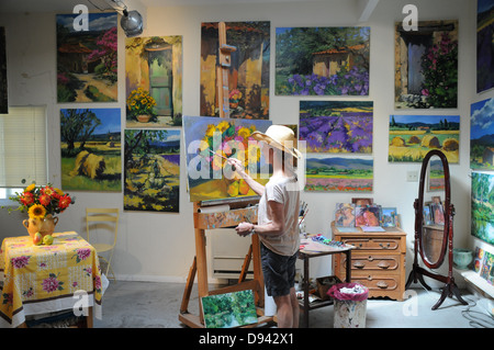 Peinture femme artiste still life sujets en studio entouré de ses œuvres au studio à Laguna Beach, Californie Banque D'Images