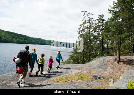 Famille de quatre enfants à marcher le long du lac Banque D'Images