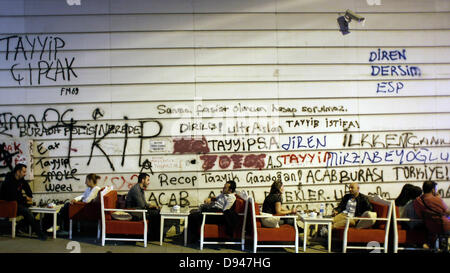 Istanbul, Turquie. 10 Juin, 2013. Les gens s'asseoir dans un café en face d'un mur de graffitis contre le gouvernement, Istanbul le 10 juin 2013. Credit : Konstantinos Tsakalidis/Alamy Live News Banque D'Images