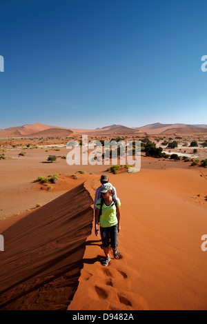 Escalade de la famille dune de sable à Sossusvlei, Namib-Naukluft National Park, Namibie, Afrique Banque D'Images