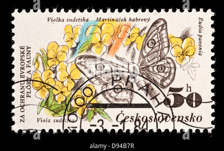 Timbre-poste de la Tchécoslovaquie représentant un petit papillon empereur (Eudia pavonia) sur une montagne pensées (Viola sudetica Banque D'Images