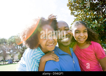 Père et filles smiling in park Banque D'Images